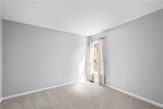 unfurnished room with carpet floors, a textured ceiling, and baseboards