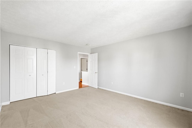 unfurnished bedroom with carpet flooring, baseboards, and a closet