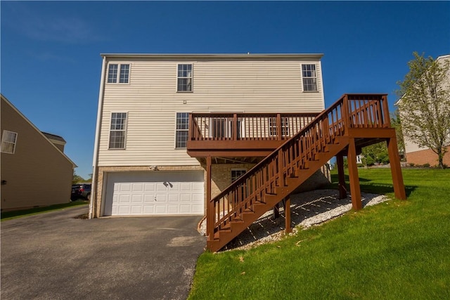 rear view of house with a garage, a wooden deck, stairway, a lawn, and driveway