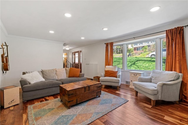 living room with recessed lighting, wood finished floors, visible vents, ornamental molding, and stairway