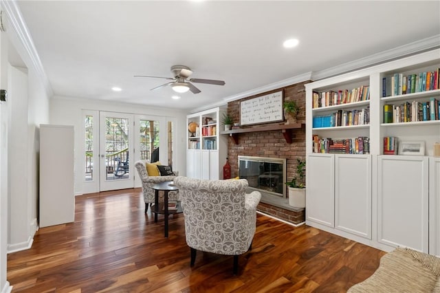 sitting room featuring ornamental molding, a brick fireplace, ceiling fan, dark wood-type flooring, and recessed lighting
