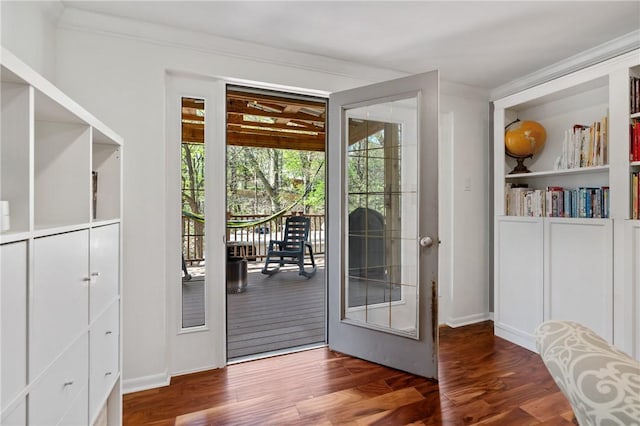 doorway with baseboards, ornamental molding, and wood finished floors