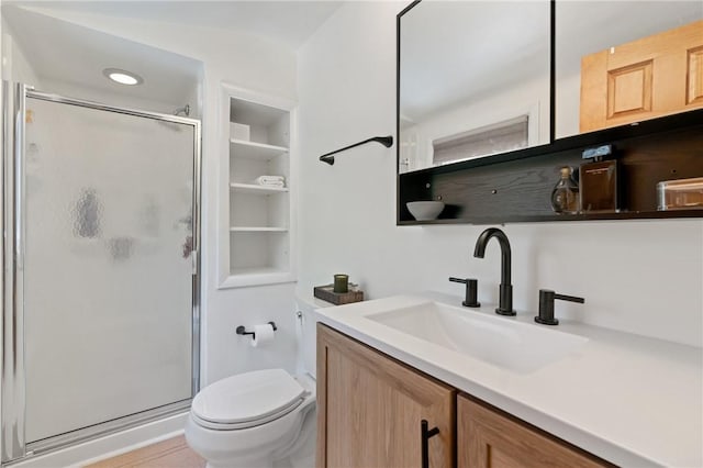 bathroom featuring vanity, toilet, and a shower stall