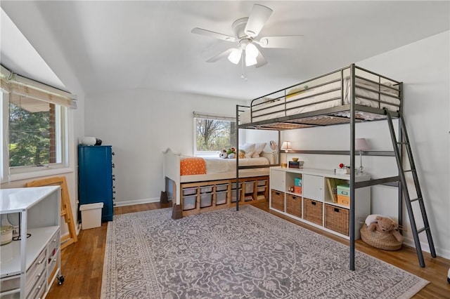 bedroom with baseboards, wood finished floors, and lofted ceiling