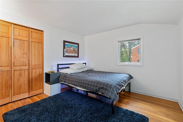 bedroom with a closet, baseboards, and light wood-style floors