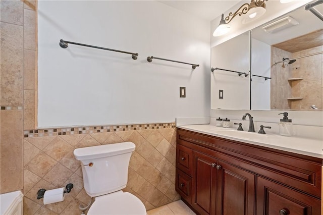 bathroom with vanity, a wainscoted wall, toilet, and tile walls