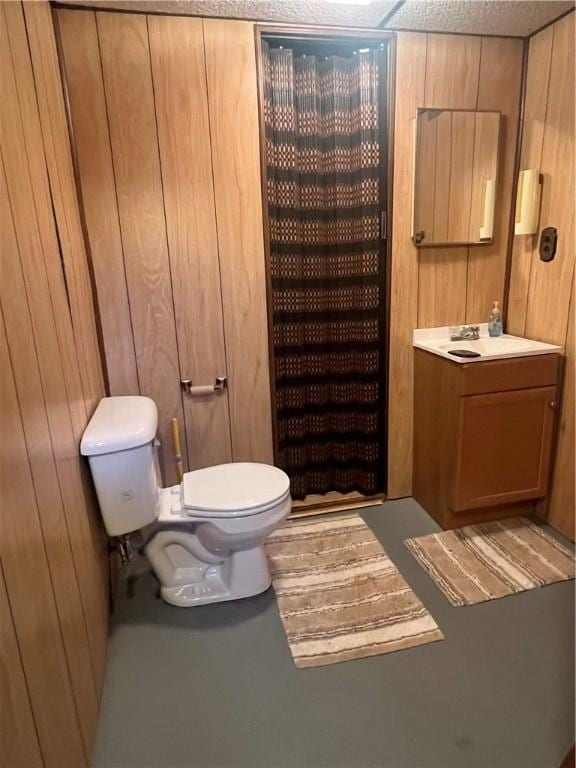 full bathroom featuring wooden walls, toilet, a shower with shower curtain, and vanity