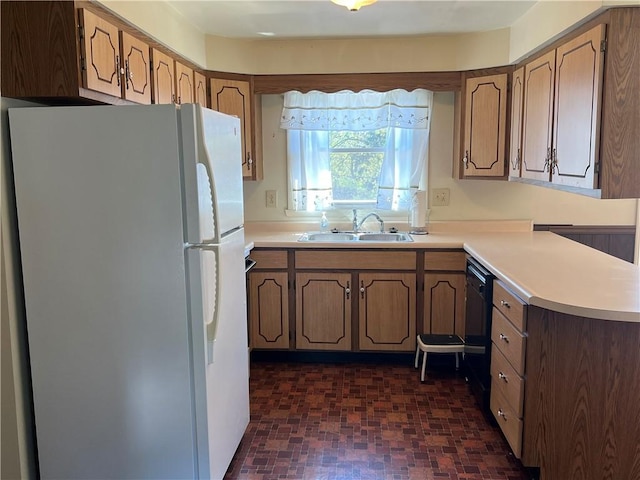 kitchen with freestanding refrigerator, light countertops, a sink, and dishwasher