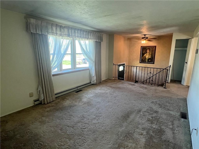 unfurnished living room featuring baseboard heating, carpet floors, a textured ceiling, a ceiling fan, and visible vents