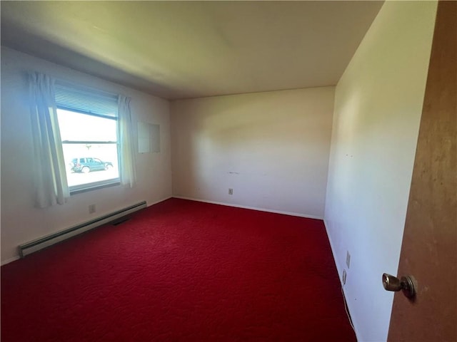 carpeted spare room featuring a baseboard heating unit