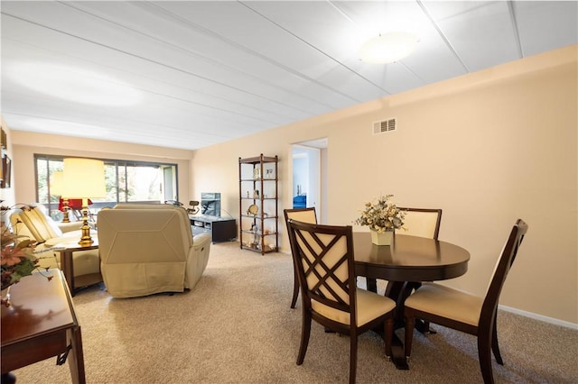 dining room with light colored carpet and visible vents