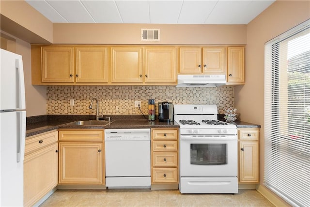 kitchen featuring visible vents, light brown cabinets, white appliances, under cabinet range hood, and a sink