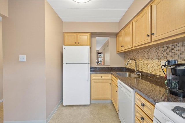 kitchen with decorative backsplash, white appliances, baseboards, dark stone counters, and a sink