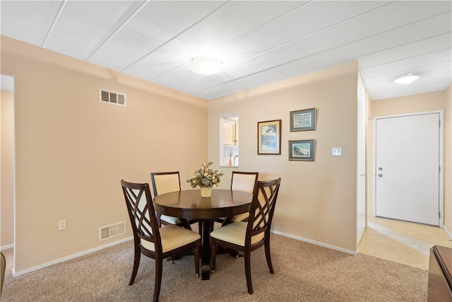 dining room featuring visible vents, baseboards, and light colored carpet