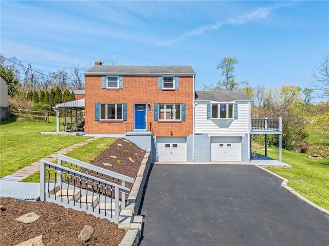view of front of home featuring a garage, a chimney, a front lawn, and aphalt driveway