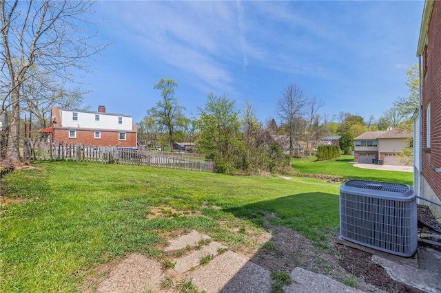 view of yard featuring central AC and fence