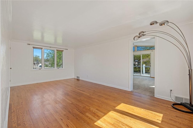 unfurnished living room with crown molding and wood finished floors
