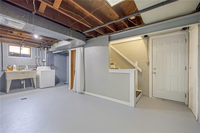 below grade area featuring visible vents, a sink, stairs, and washer / clothes dryer