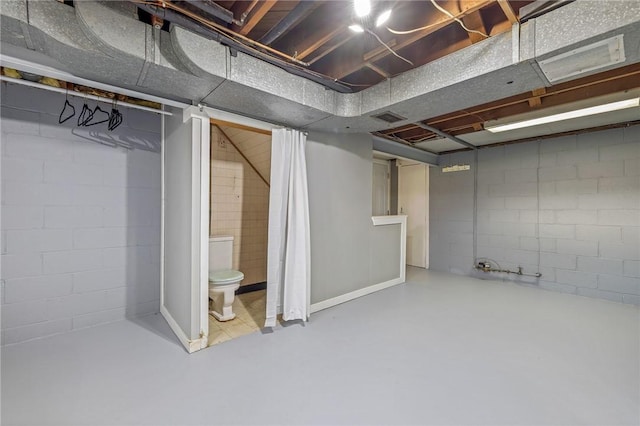 unfinished basement featuring visible vents and concrete block wall