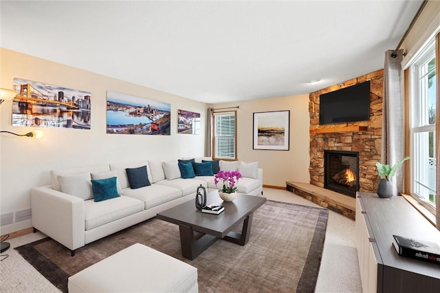 living room featuring carpet, baseboards, and a fireplace