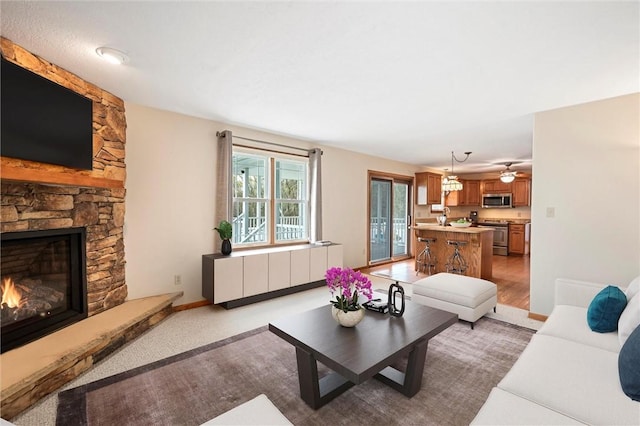 living room with ceiling fan and a fireplace