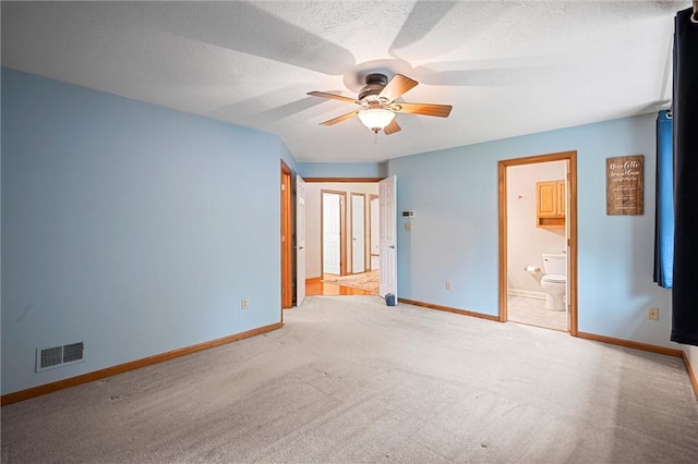 unfurnished bedroom featuring baseboards, carpet flooring, a textured ceiling, and visible vents