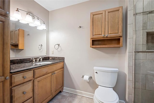 full bathroom with vanity, toilet, baseboards, tiled shower, and tile patterned floors
