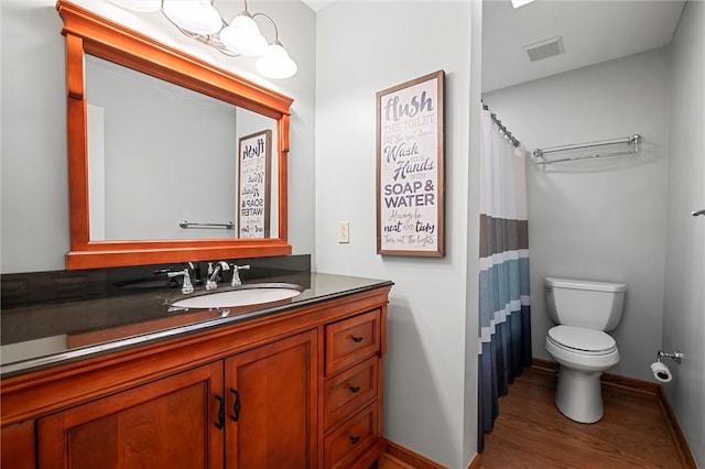 full bathroom with vanity, baseboards, toilet, and wood finished floors