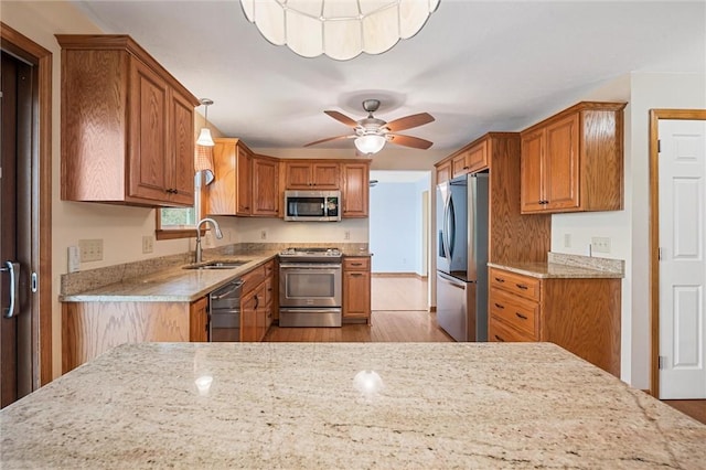 kitchen with brown cabinets, appliances with stainless steel finishes, and a sink