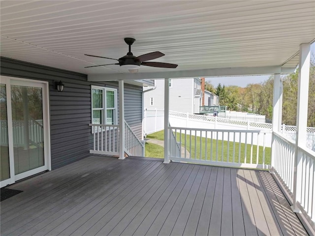 wooden deck featuring fence private yard, ceiling fan, and a yard