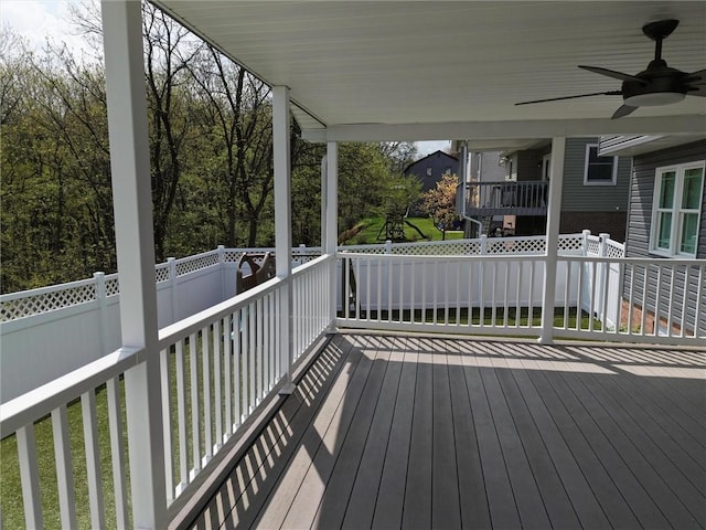 wooden terrace with ceiling fan and fence