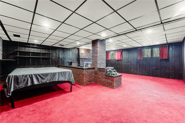 bedroom featuring carpet floors, a paneled ceiling, and wooden walls