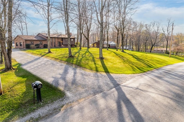 exterior space featuring a lawn and gravel driveway