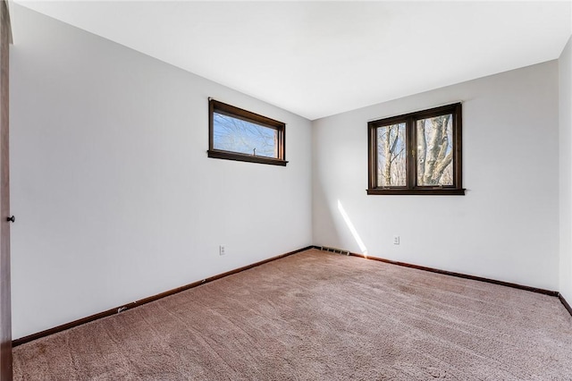 unfurnished room featuring carpet floors, baseboards, and visible vents