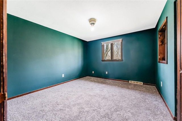 spare room with visible vents, baseboards, and carpet floors