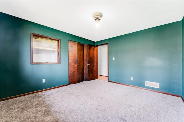 unfurnished bedroom with carpet floors, baseboards, and visible vents