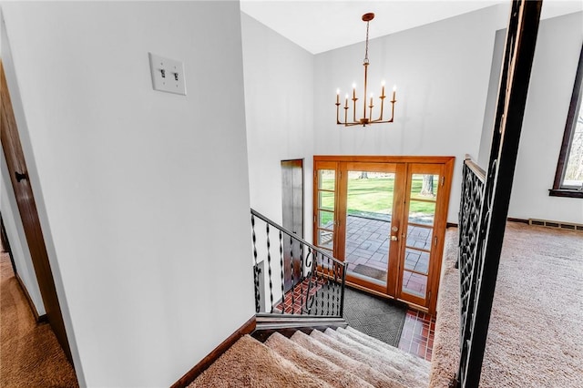 foyer with an inviting chandelier, carpet floors, and a healthy amount of sunlight