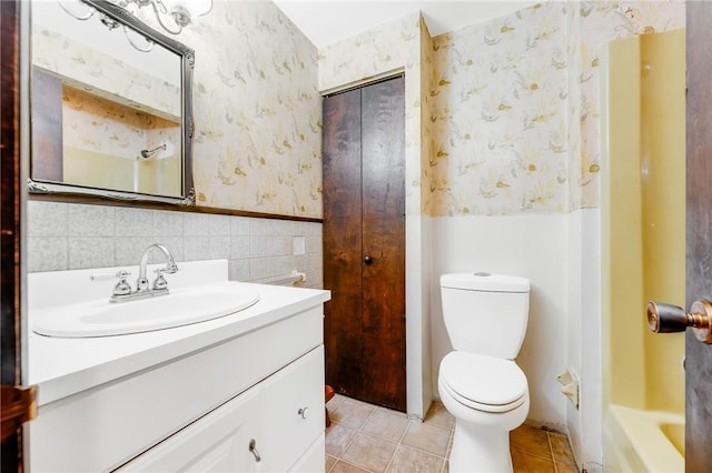 full bath featuring vanity, toilet, tile patterned floors, a wainscoted wall, and wallpapered walls
