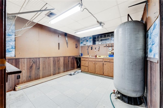 interior space featuring light floors, wainscoting, and wooden walls