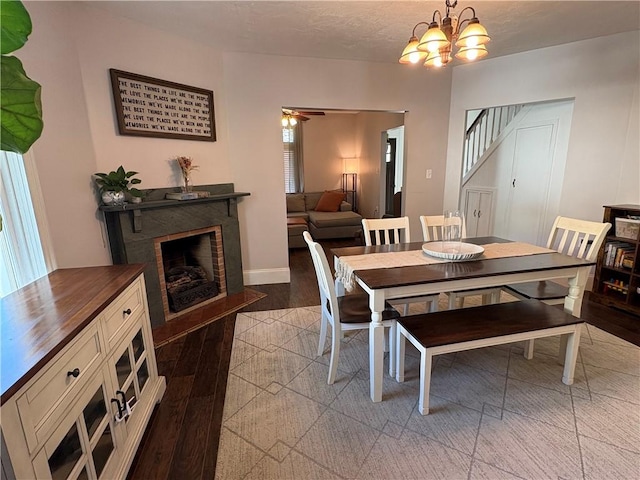 315 Taylor Ave, Bellevue, PA 15202 - dining room featuring a fireplace, baseboards, a notable chandelier, light wood-style floors, and stairs