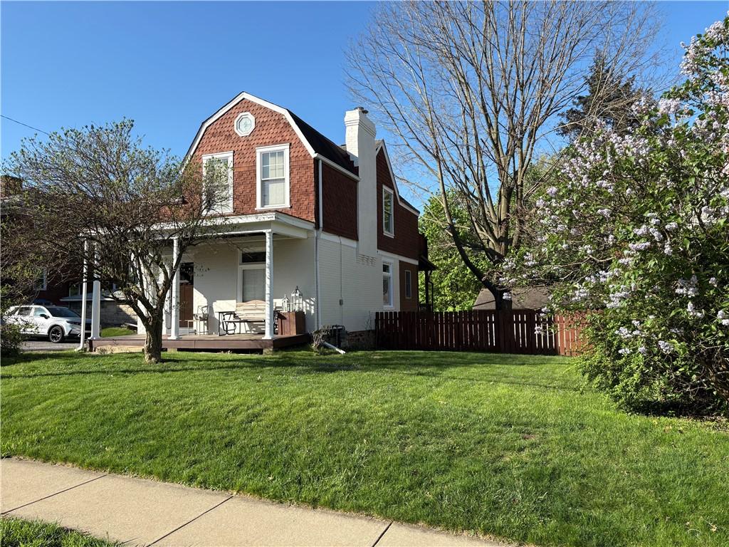 315 Taylor Ave, Bellevue, PA 15202 - view of property exterior with fence, a gambrel roof, a porch, a chimney, and a lawn