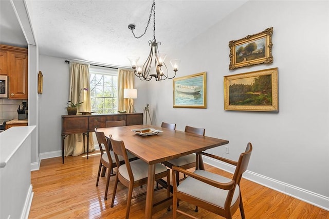 5983 Daleview Dr, Bethel Park, PA 15102 - dining space with light wood-style floors, baseboards, a textured ceiling, and a chandelier