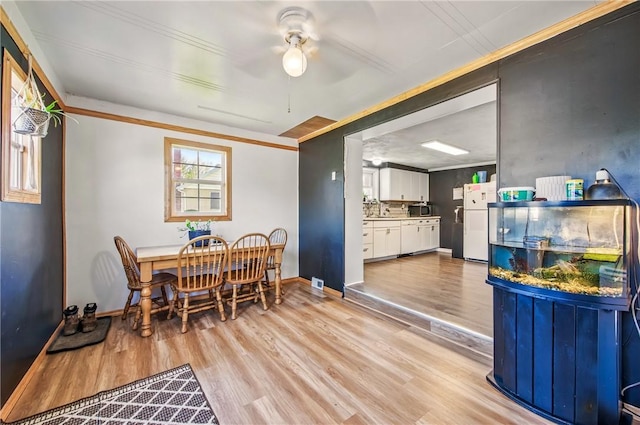 dining area featuring crown molding, ceiling fan, and light wood-type flooring