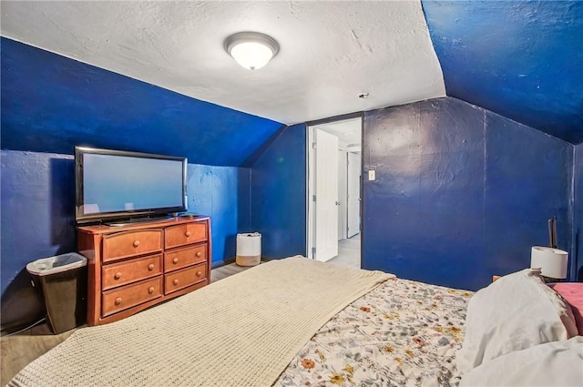bedroom featuring a textured ceiling and lofted ceiling