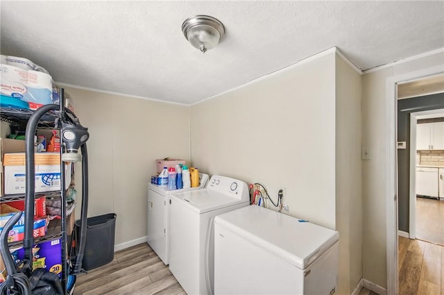 washroom with crown molding, laundry area, separate washer and dryer, baseboards, and light wood-type flooring
