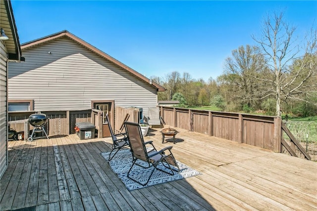 wooden deck featuring a fire pit and area for grilling