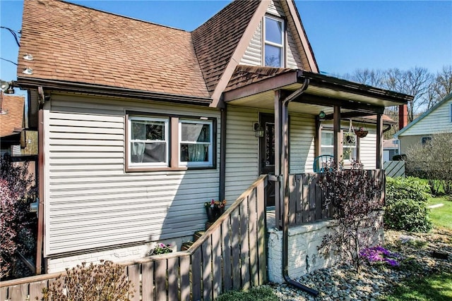 view of front of home with covered porch and a shingled roof