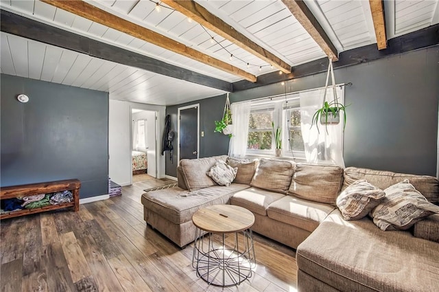living area with beamed ceiling, wooden ceiling, baseboards, and hardwood / wood-style flooring