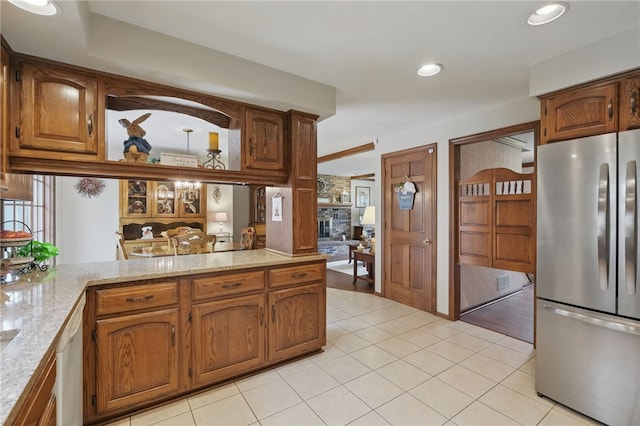 1058 Rimrock Rd, City Of Greensburg, PA 15601 - kitchen featuring a fireplace, brown cabinets, light tile patterned floors, freestanding refrigerator, and recessed lighting