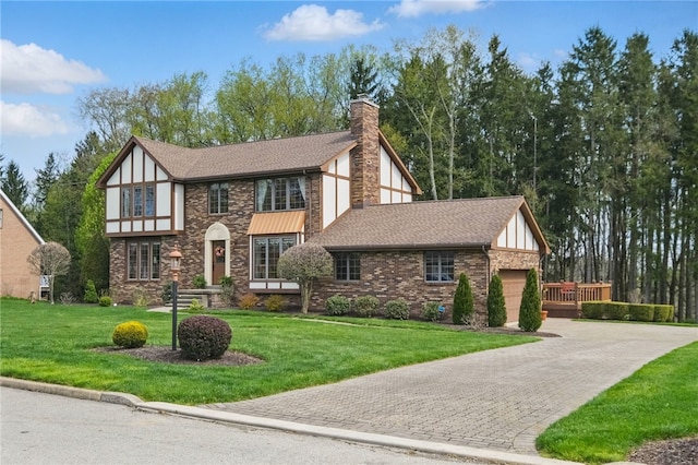 1058 Rimrock Rd, City Of Greensburg, PA 15601 - english style home featuring roof with shingles, an attached garage, a front yard, a chimney, and decorative driveway